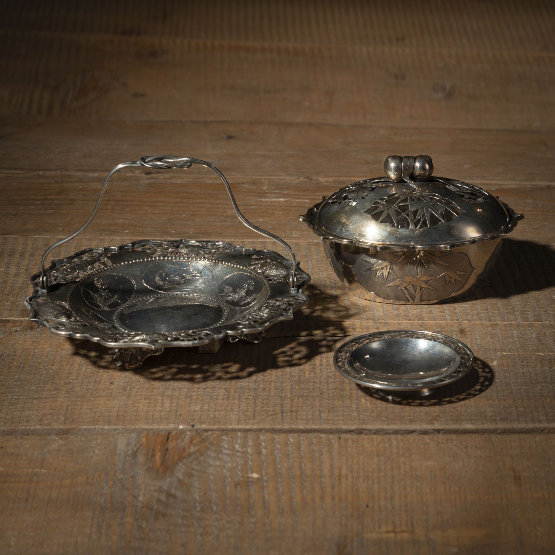 A SILVER COVERED BOWL, A BOWL WITH HANDLE AND A SMALL BOWL WITH FLORAL DECORATION, PARTLY IN OPENWO