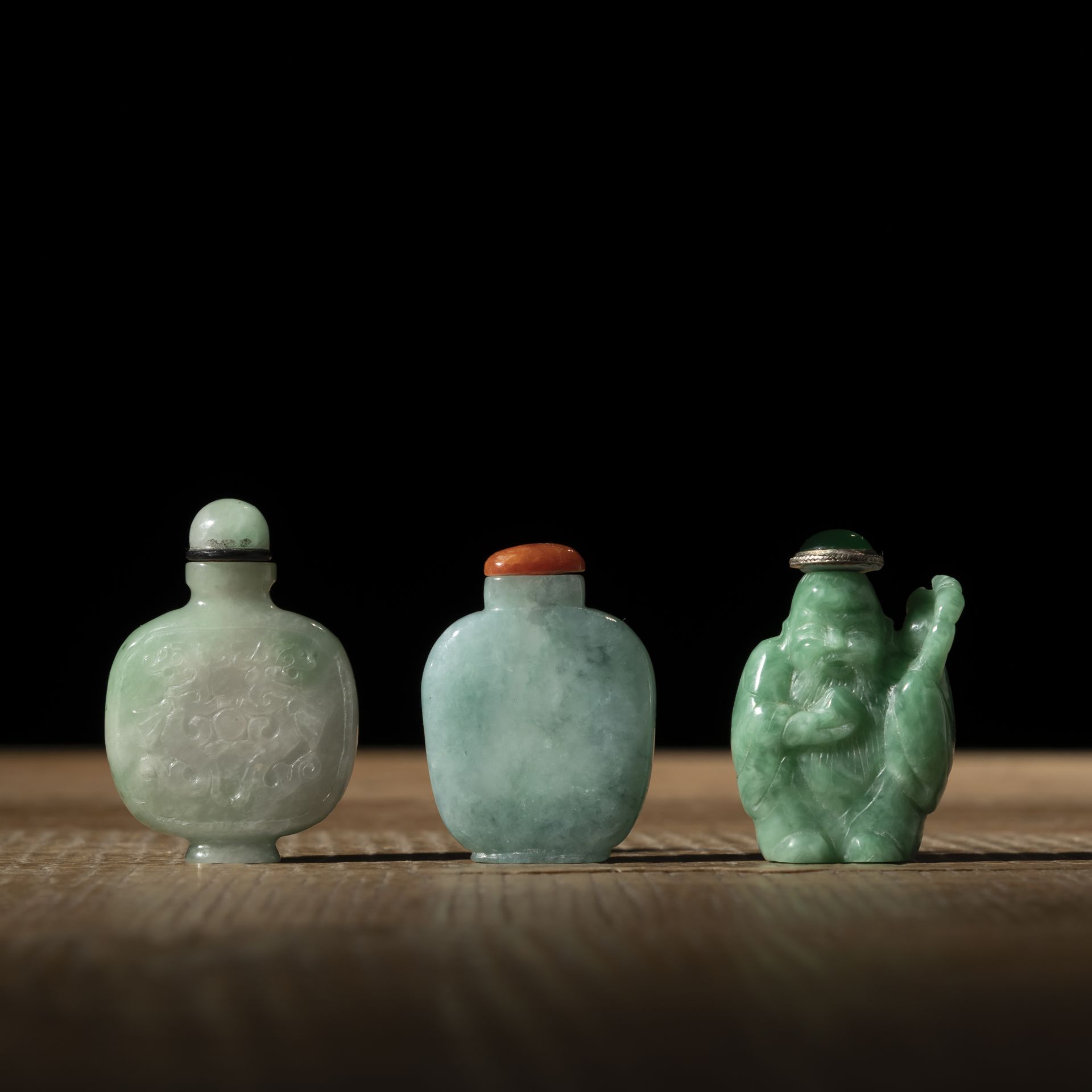 TWO JADE SNUFF BOTTLES, PARTLY CARVED WITH DRAGONS, AND ANOTHER SNUFF BOTTLE IN THE SHAPE OF THE SH