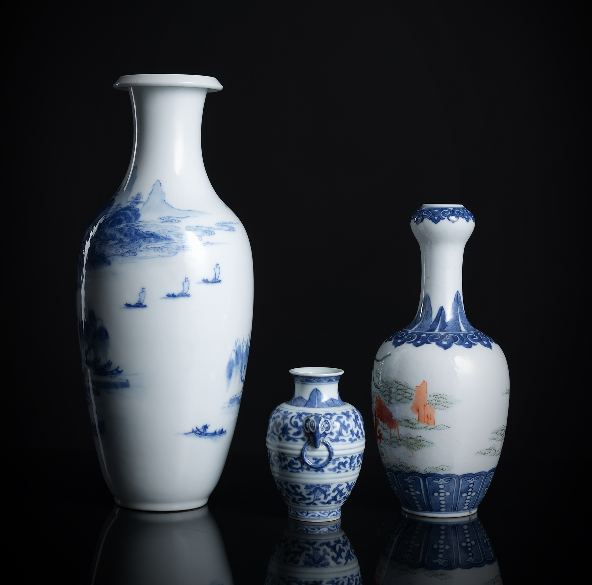 A GROUP OF THREE BLUE AND WHITE PORCELAIN VASES, ONE WITH ADDITIONAL DECORATED FAMILLE ROSE SCENE