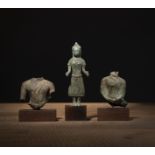 Zwei Torso-Fragmente und ein stehender Buddha aus Bronze
