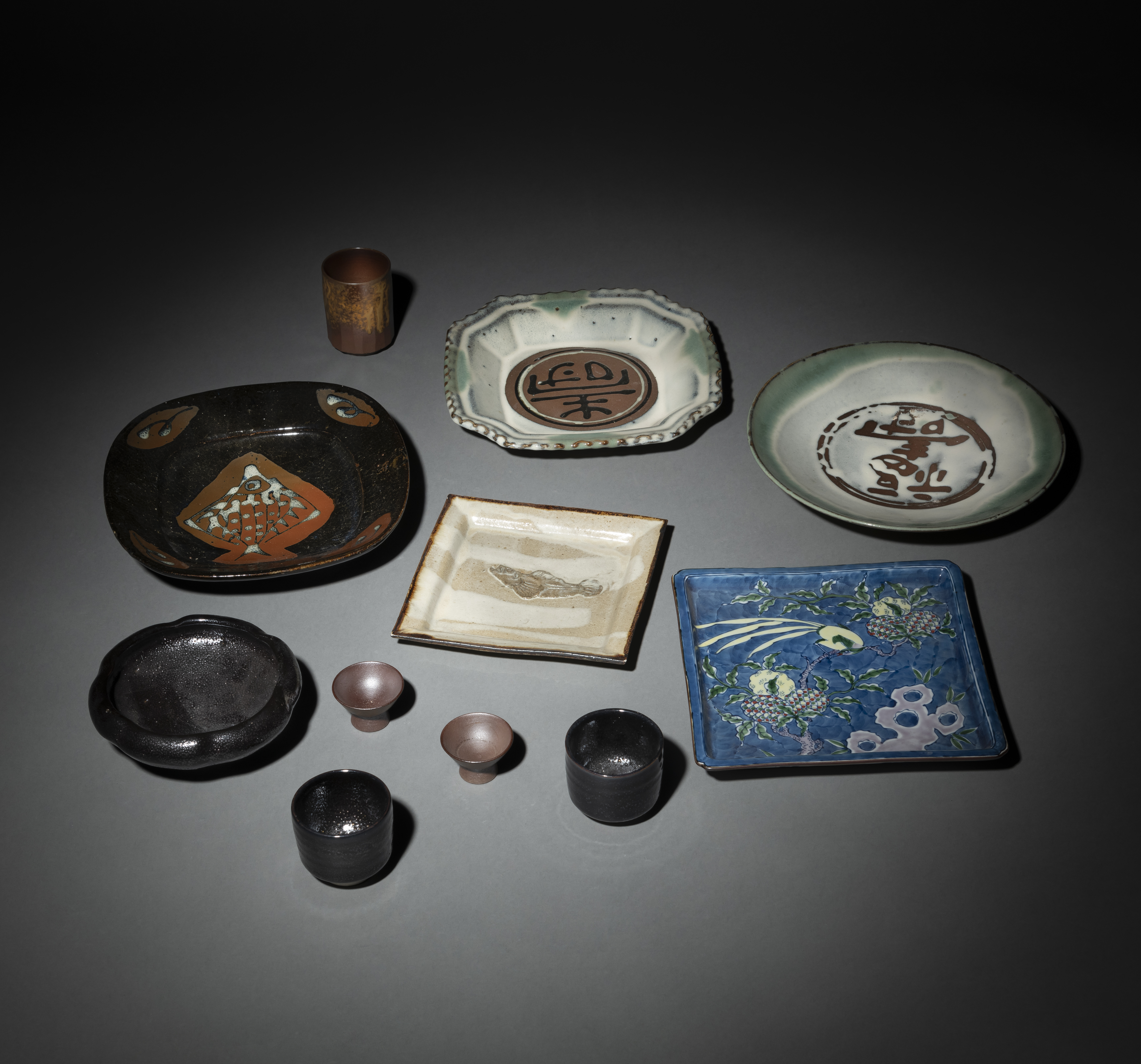 A GROUP OF STUDIO CERAMICS: TWO SQUARE AND THREE ROUND PLATES, A TEA BOWL, THREE TEA CUPS AND A PAI