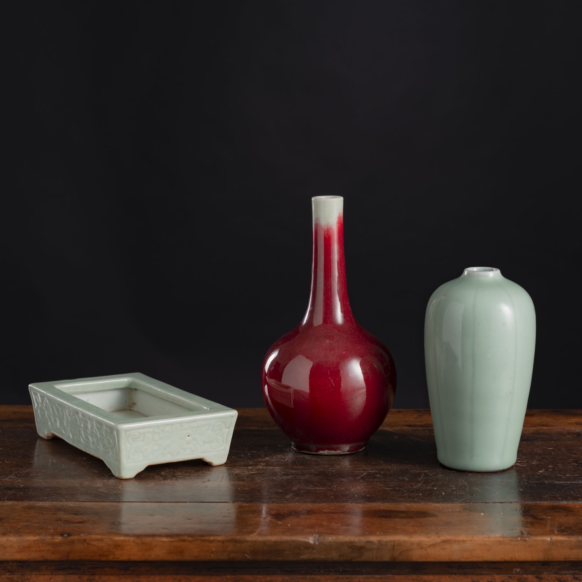 A SMALL COPPER-RED BOTTLE VASE, A CELADON VASE, AND A CELADON JARDINIÈRE