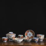 Eine Deckelschale, drei Koppchen, eine Tasse und vier blütenförmige Untertassen aus 'Imari'-Porzell