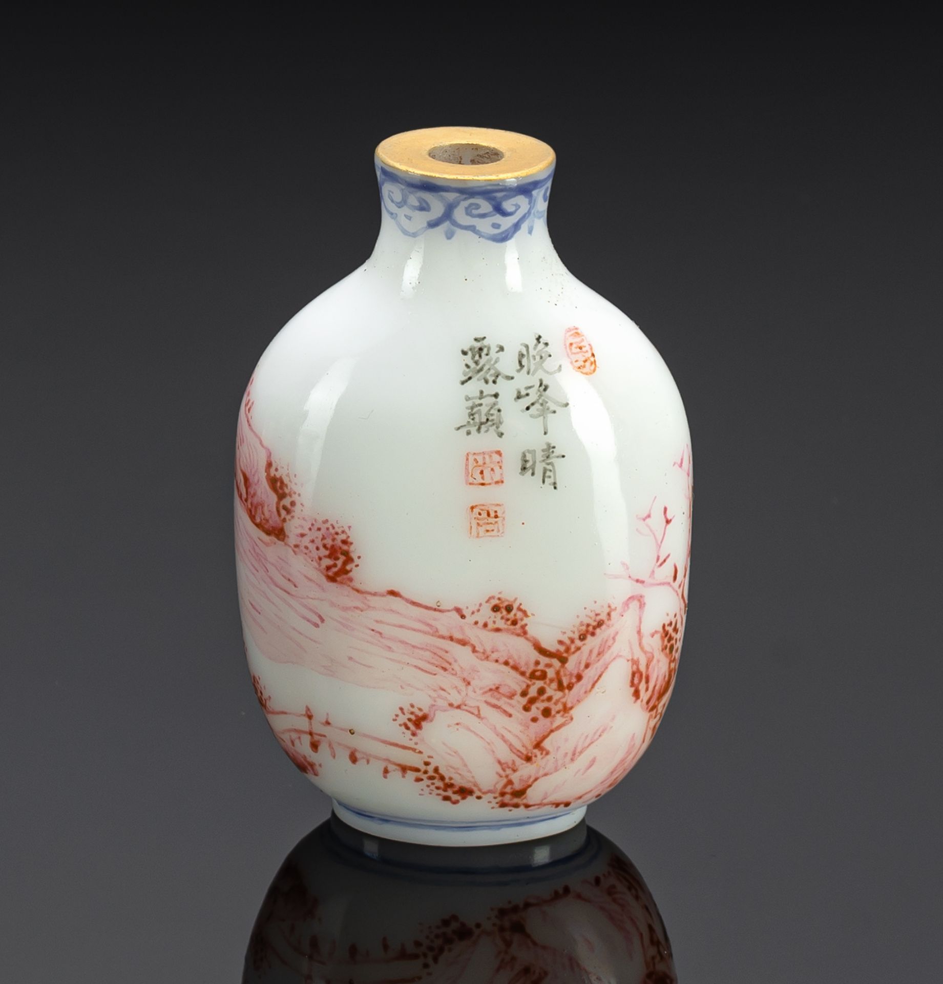 A WHITE GLASS SNUFF BOTTLE PAINTED WITH ENAMEL IN RED, BLUE AND BLACK DEPICTING A MOUNTAIN LANDSCAP