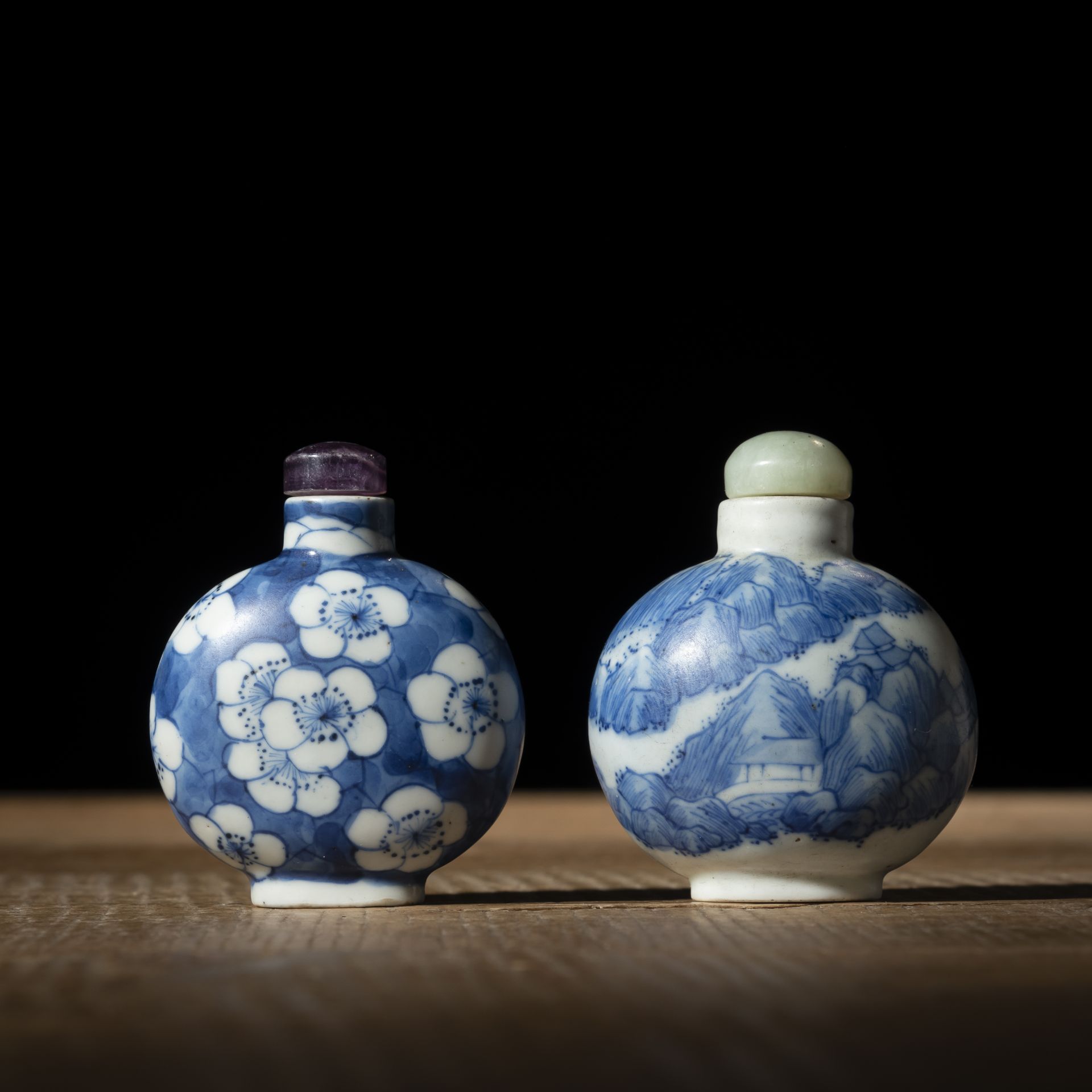 TWO BLUE AND WHITE PORCELAIN SNUFF BOTTLES DEPICTING PLUM BLOSSOMS AND A MOUNTAIN LANDSCAPE