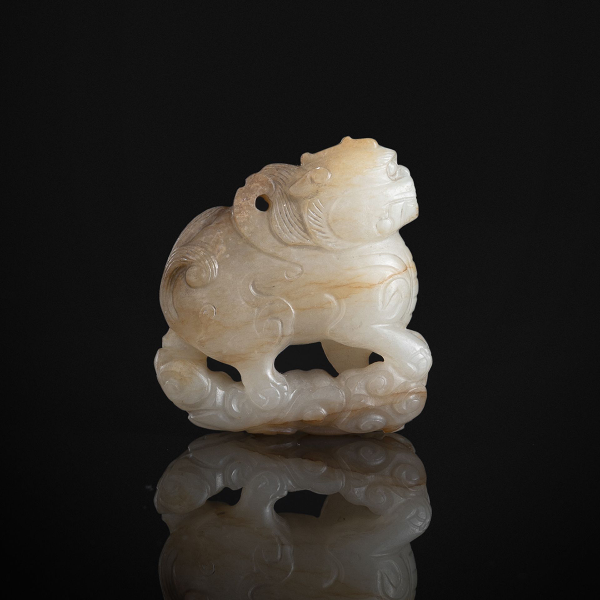 A CARVED GREEN-BEIGE JADE PENDANT OF A MYTHICAL BEAST