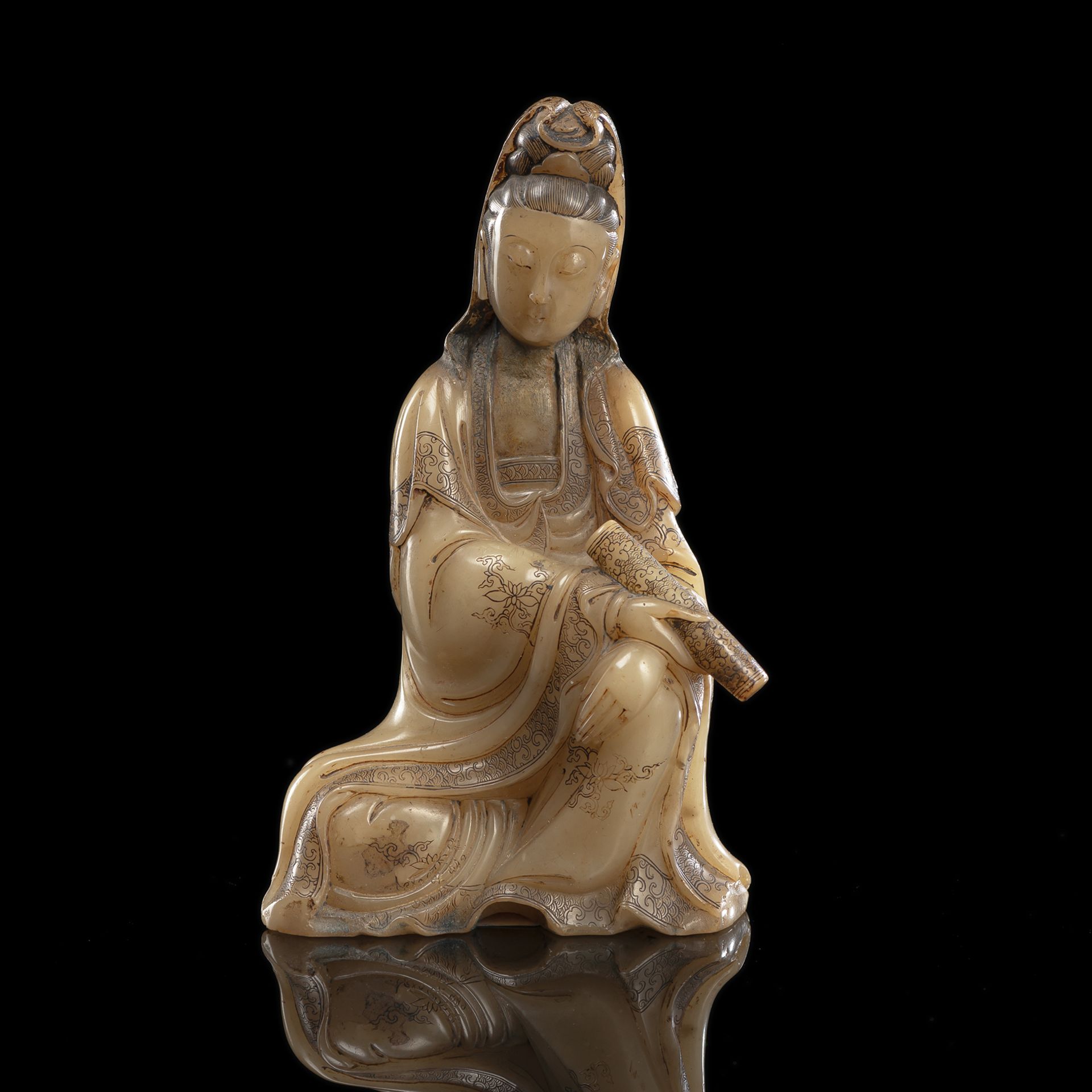 A VERY FINE CARVED AND ENGRAVED SOAPSTONE MODEL OF SEATED GUANYIN WITH A SCROLL