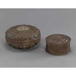 Zwei Deckeldosen aus Metall teils mit ornamentalen Dekor in Répousse-Technik und EInlagen aus Glas