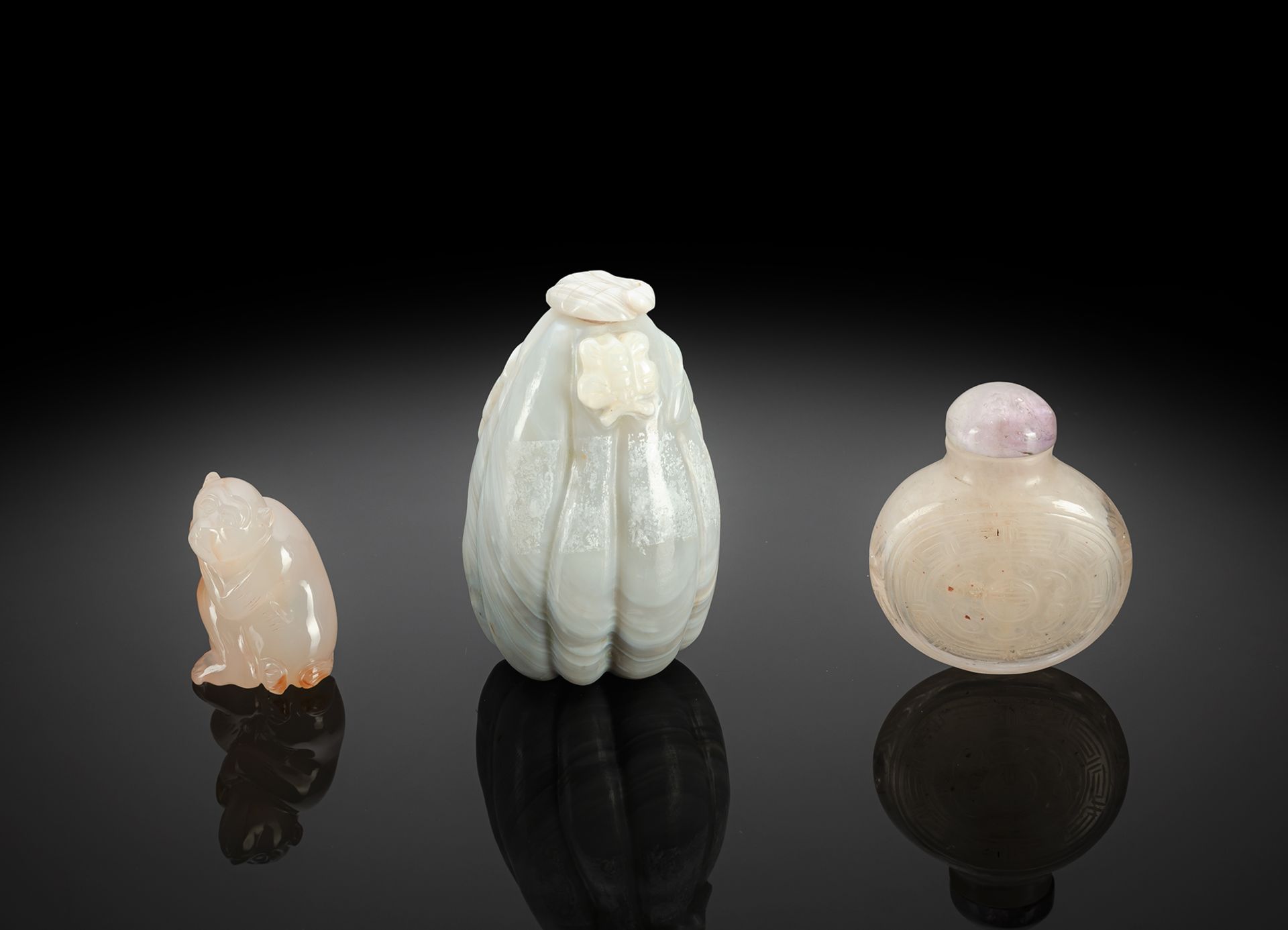 A CARVED AGATE AND A CRYSTAL SNUFFBOTTLE AND AN AGATE CARVING OF A SEATED MONKEY