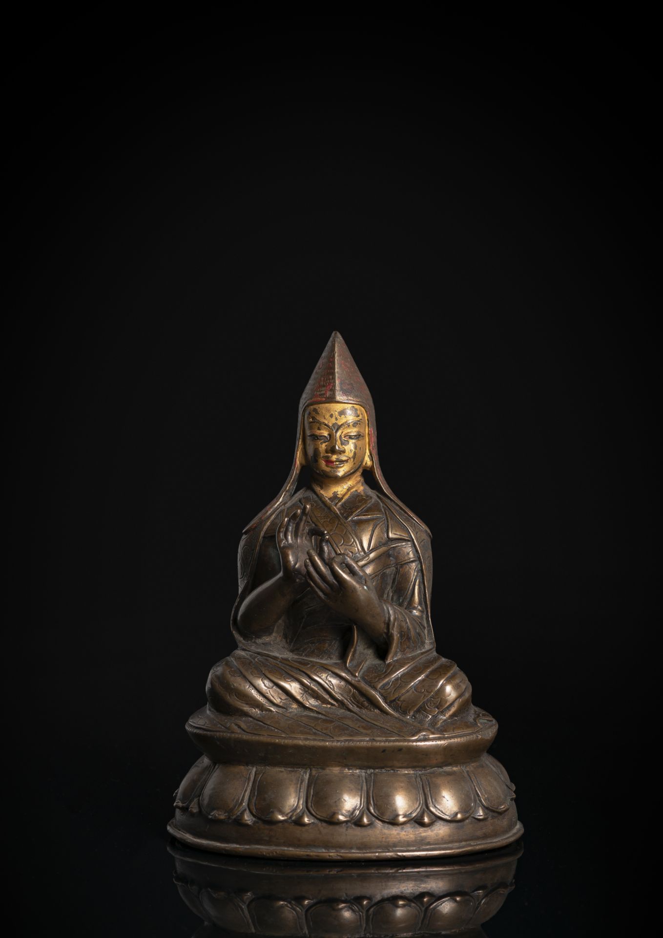 A BRONZE FIGURE OF A LAMA