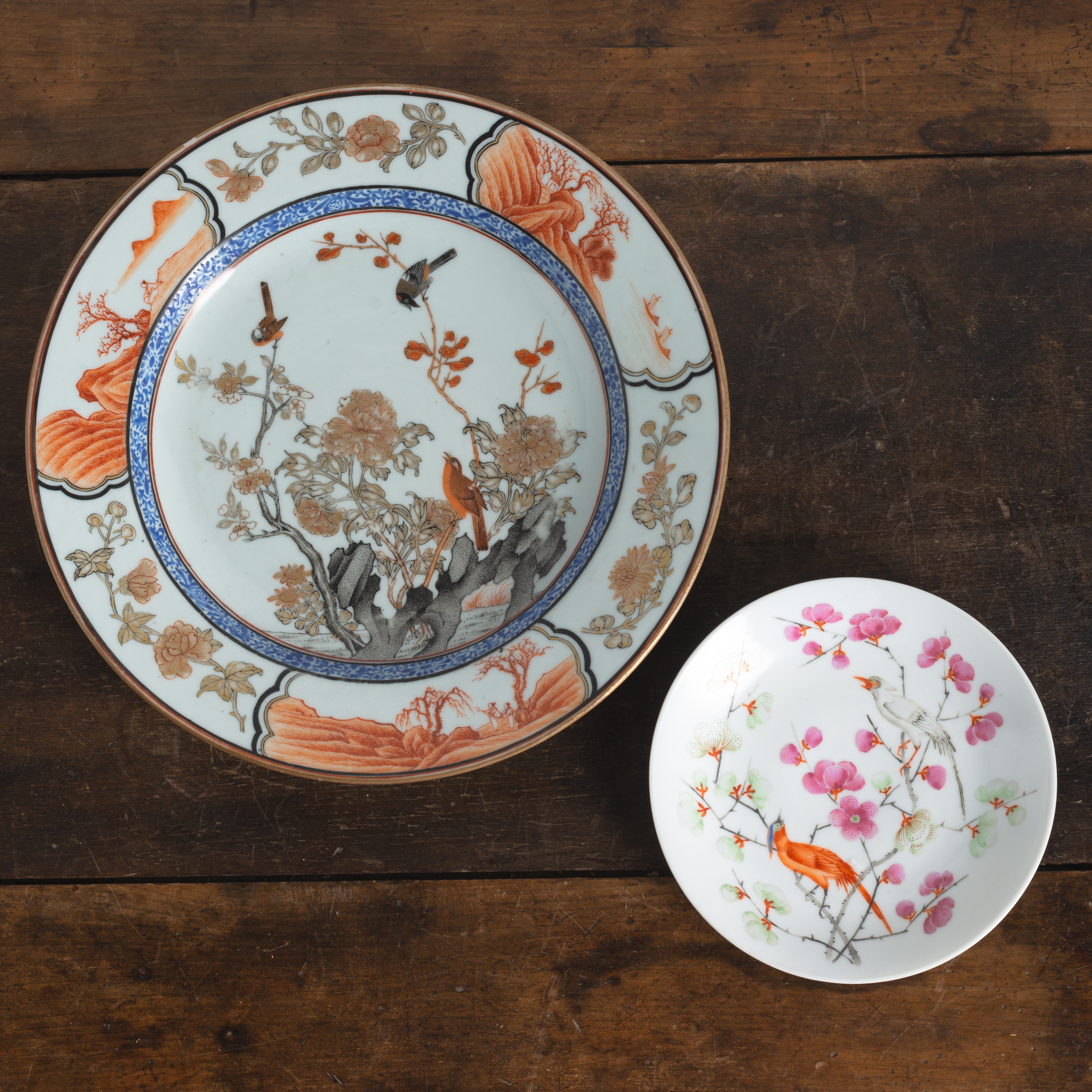 AN IRON-RED AND GILT LANDSCAPE AND BIRDS PORCELAIN PLATE AND A 'FAMILLE ROSE' SAUCER