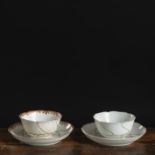 TWO GOLD-PAINTED PORCELAIN CUPS AND SAUCERS