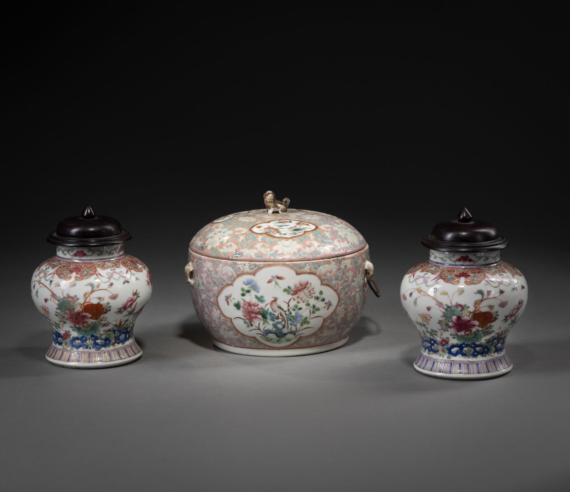 Eine Deckeldose und zwei Deckelvasen aus Porzellan mit floralem 'Famille rose'-Dekor