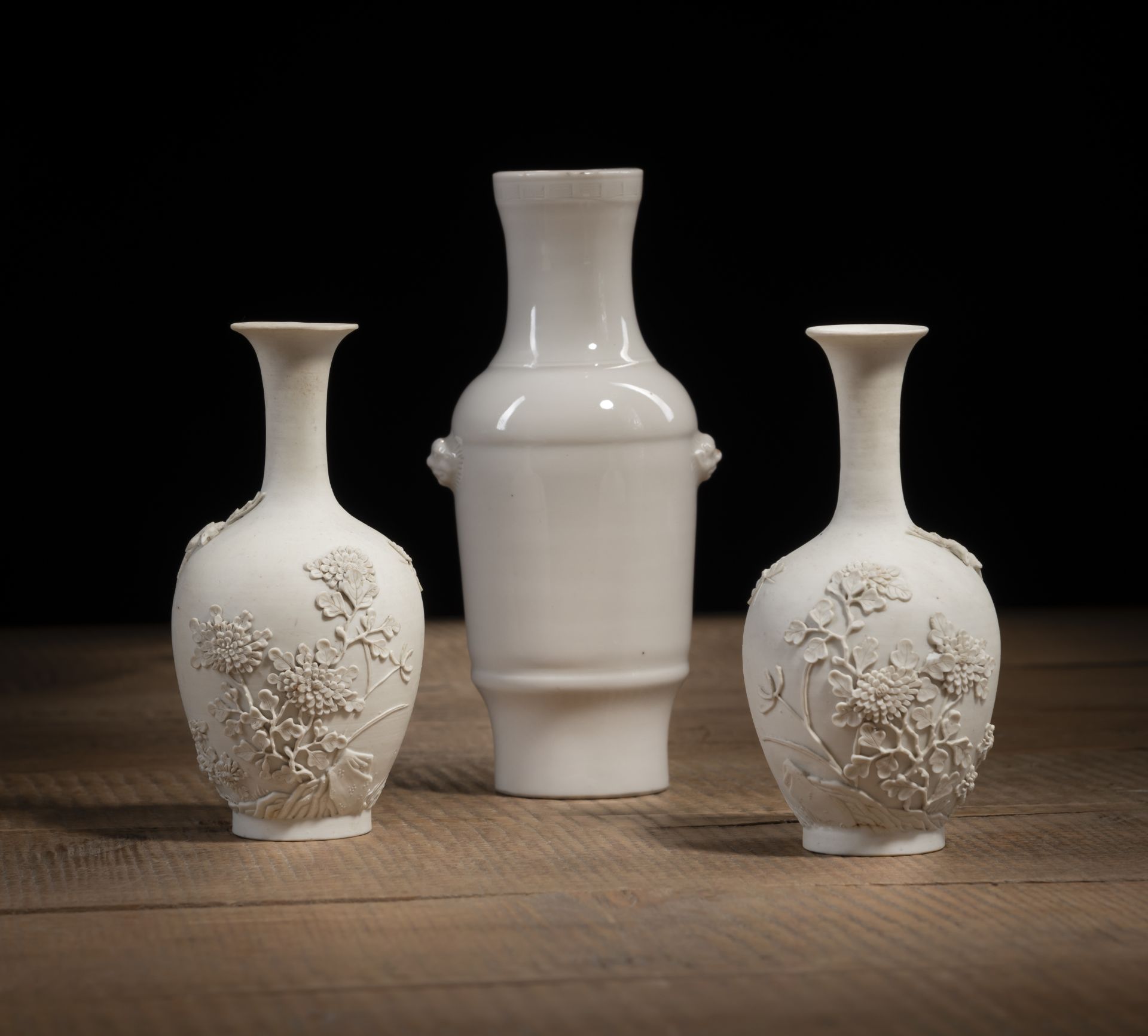 A PAIR OF BISCUIT PORCELAIN RELIEF CHRYSANTHEMUM VASES AND A DEHUA-WARE VASE