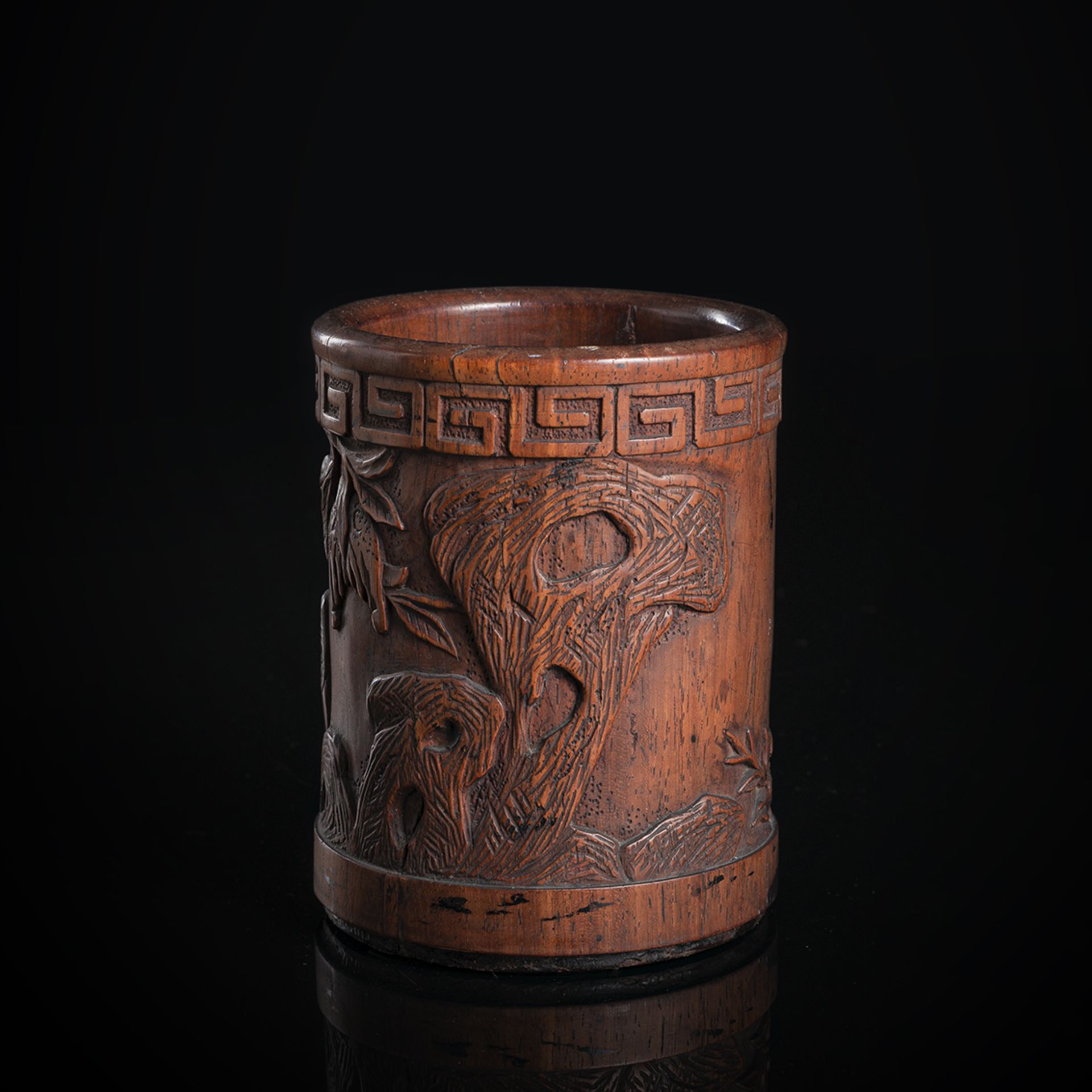 A CARVED WOOD BRUSHPOT WITH FINGER CITRONS AND ROCKS