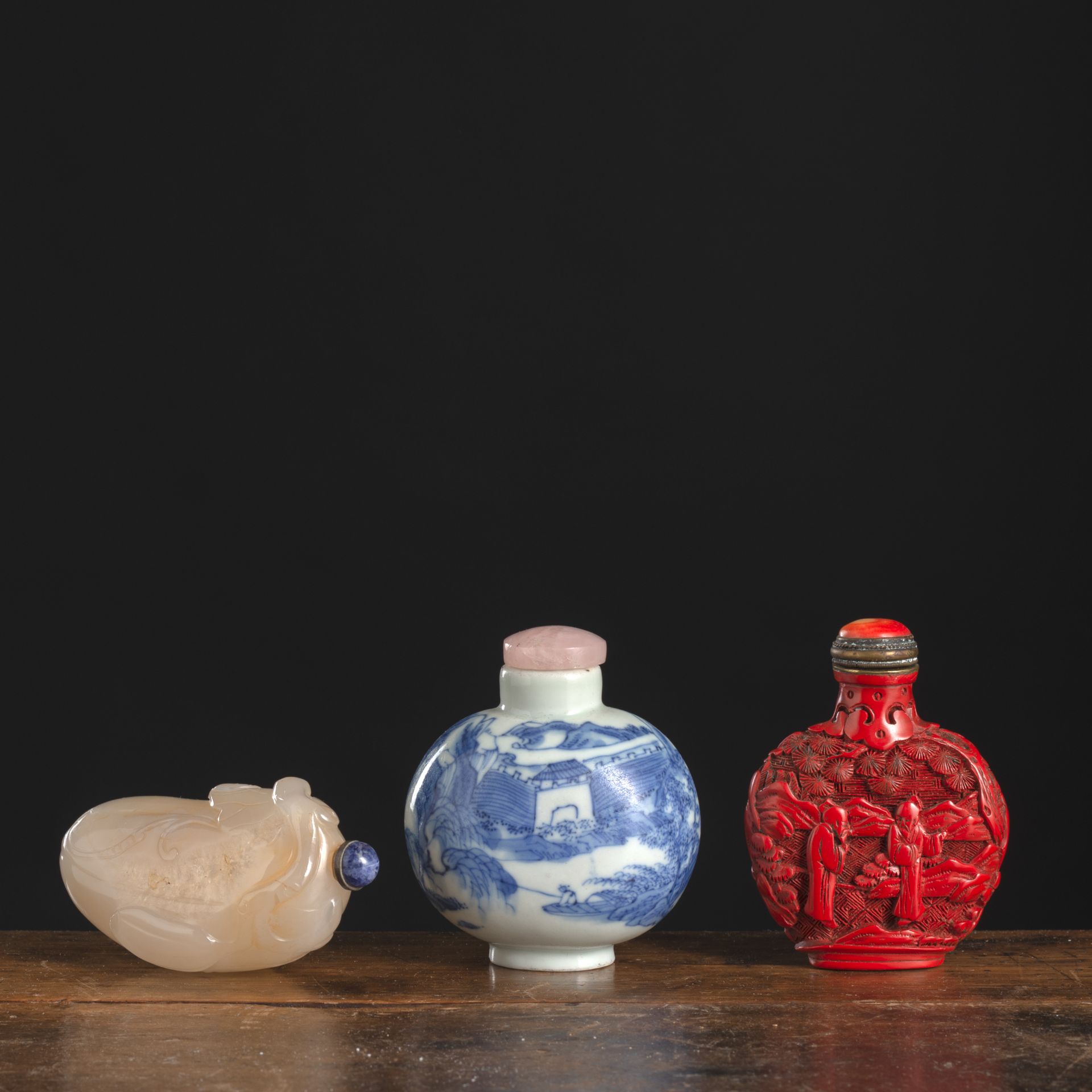 THREE RED-LACQUER, PORCELAIN, AND JADE SNUFFBOTTLES