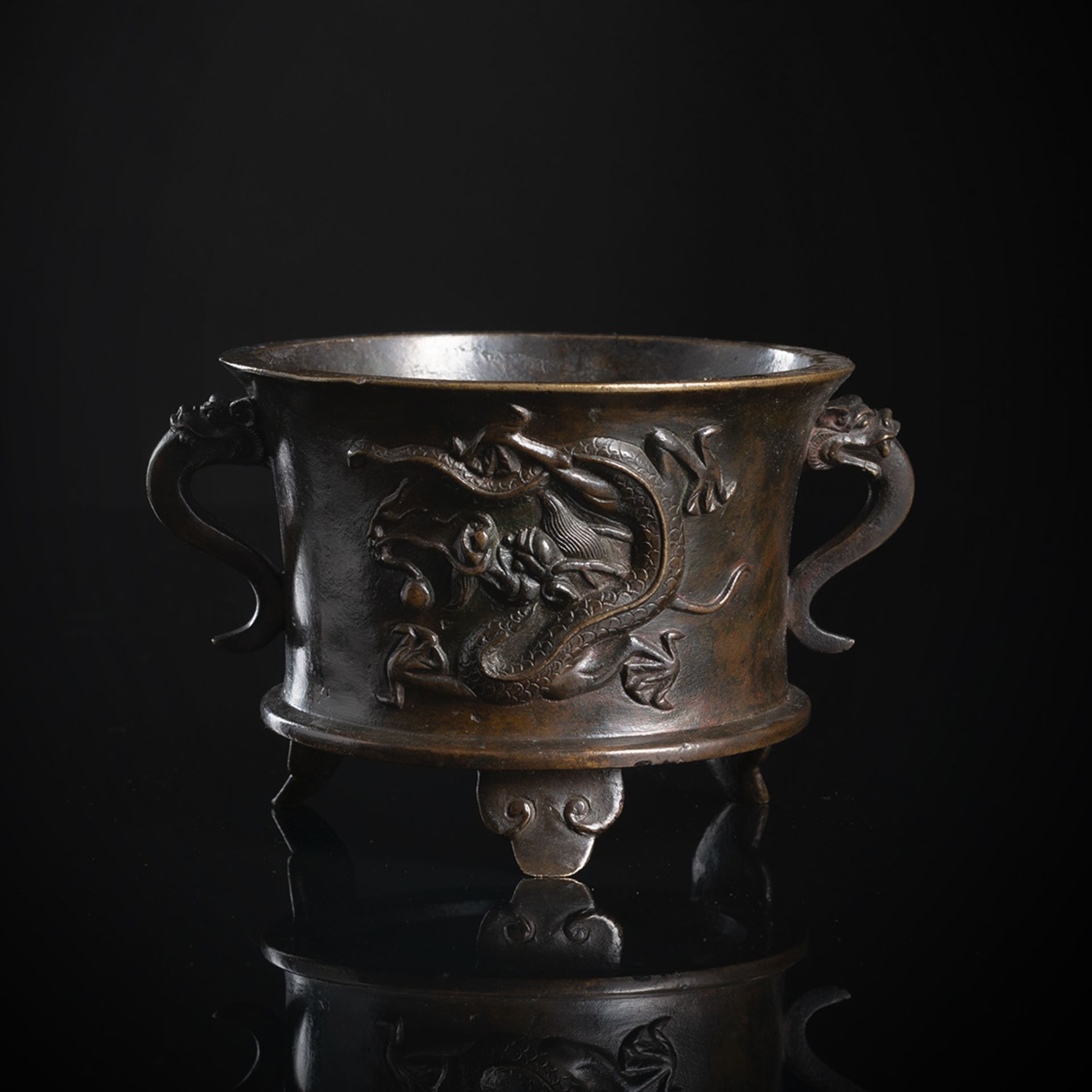 A BRONZE TRIPOD CENSER WITH HANDLES AND DRAGON DECORATION