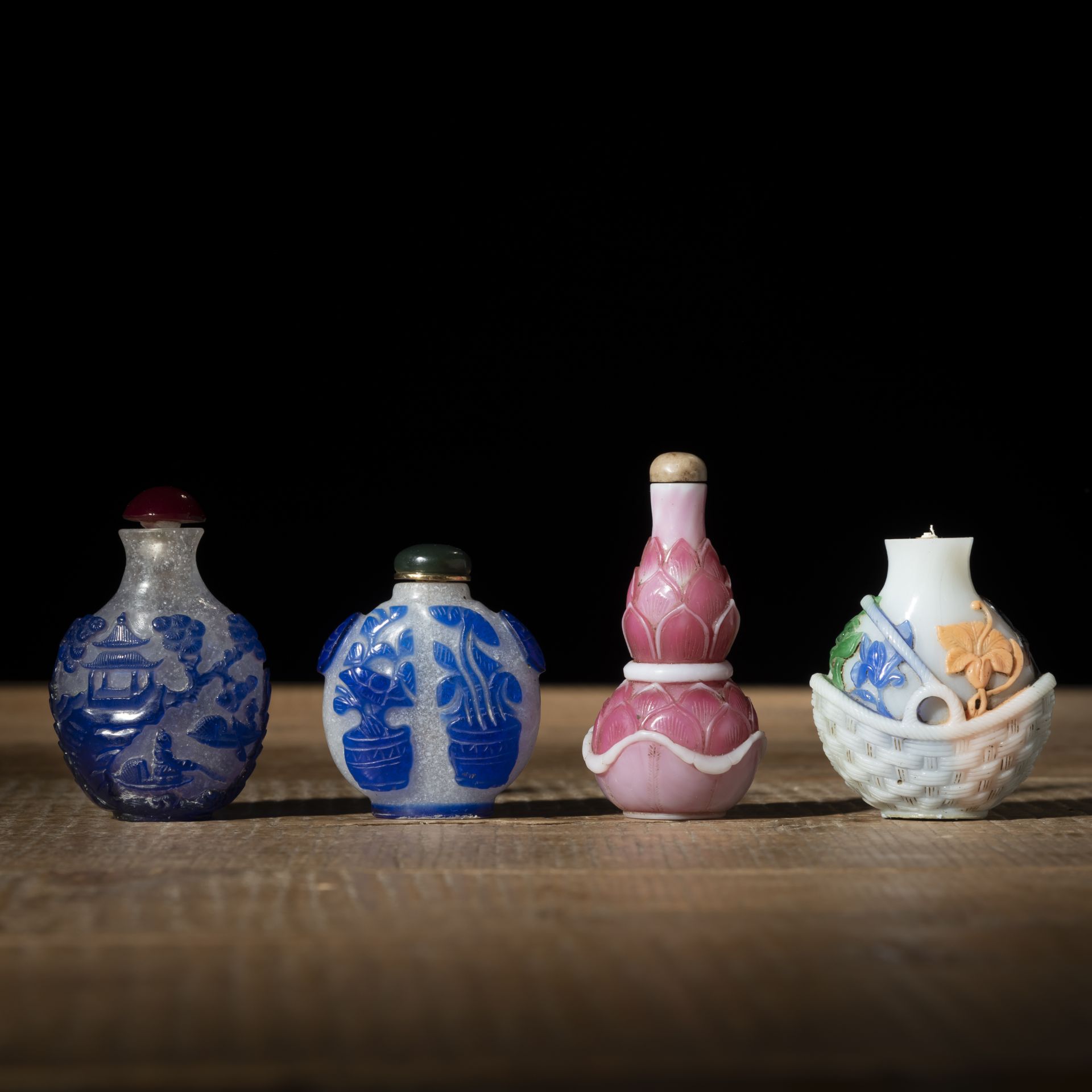 FOUR PEKING GLASS SNUFF BOTTLES WITH POLYCHOROME FLORAL AND LANDSCAPE DECORATION, PARTLY WITH BLUE