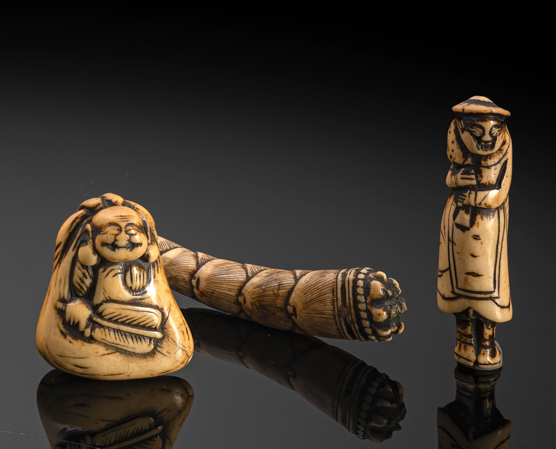 FOUR CARVED STAGANTLER NETSUKE OF FUKUROKUJU, HOTEI, A DUTCHMAN AND A BAMBOO SPROUT