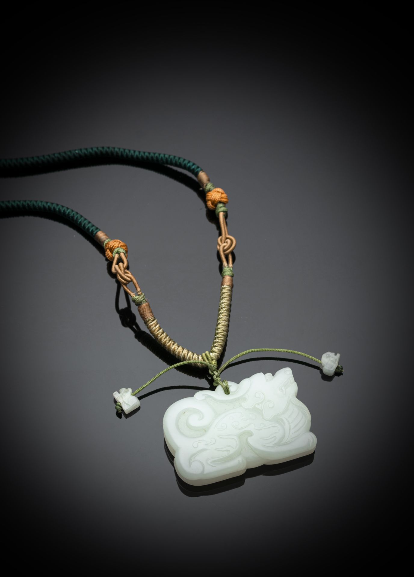 A FINELY CARVED MYTHICAL BEAST JADE PENDANT