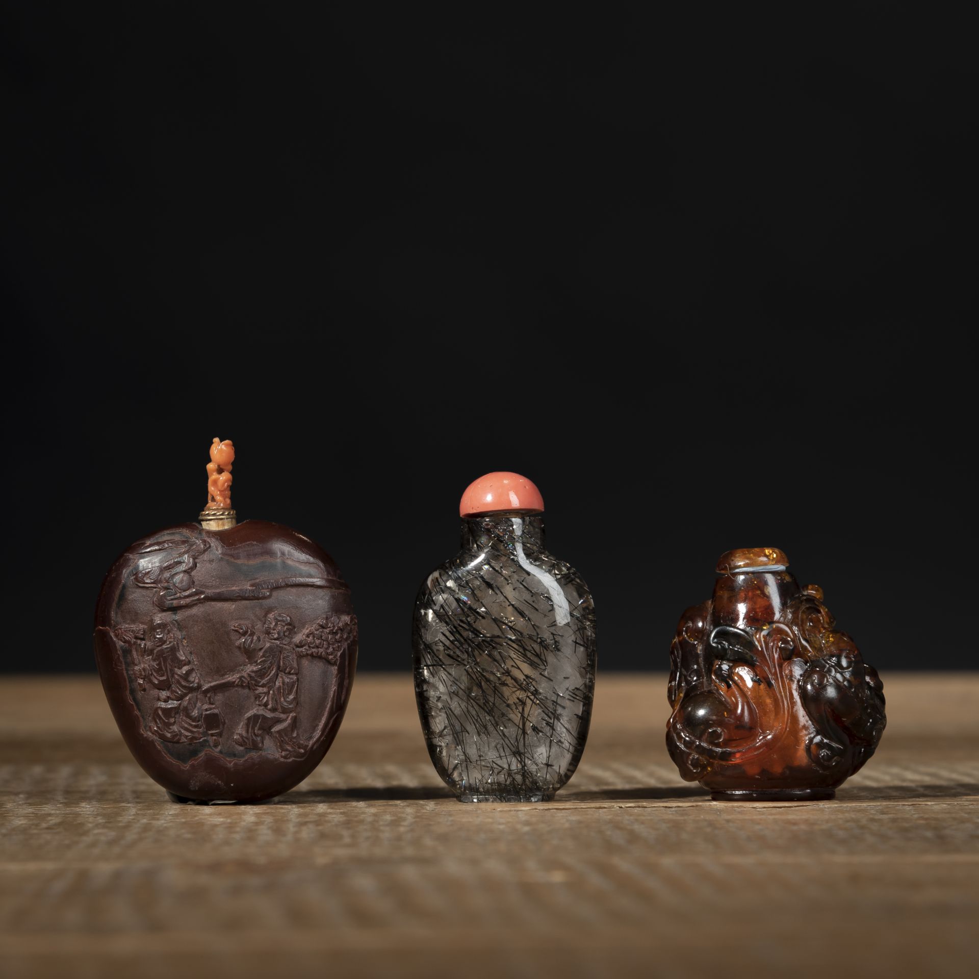 Zwei Snuffbottles aus Quartz und geschnitzter, bemalter Nussschale und ein weitere Snuffbottle mit