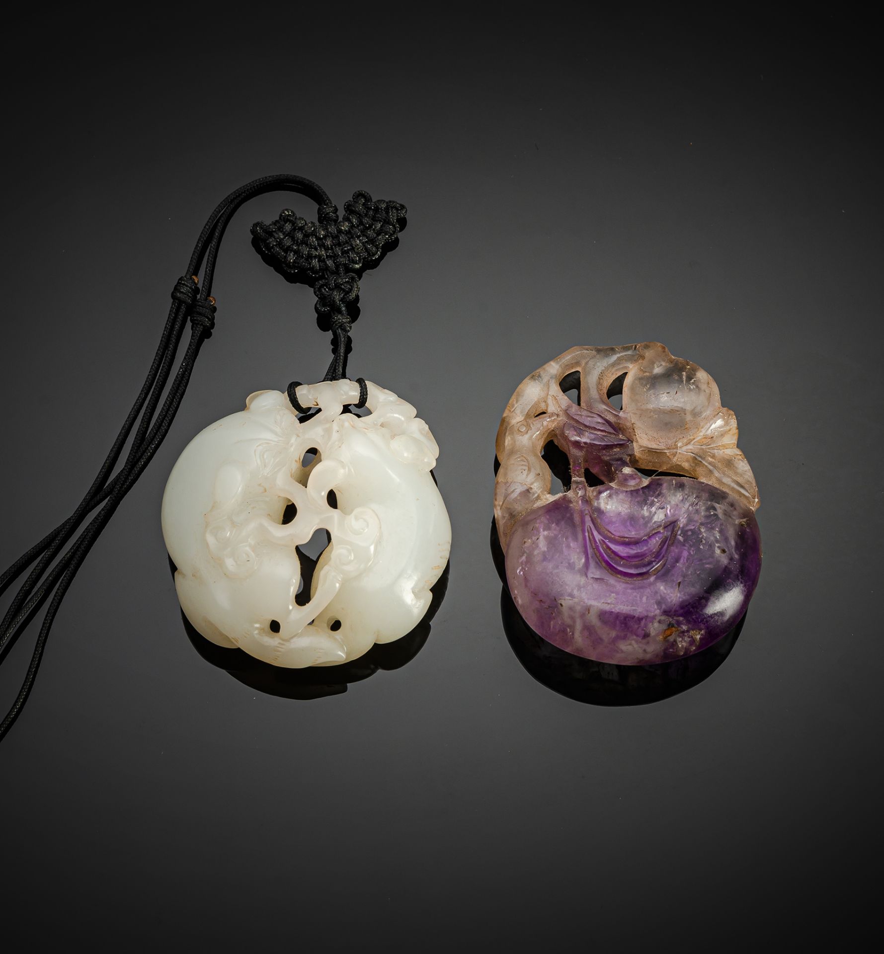 A CARVED JADE AND A CARVED AMETHYST PENDANT