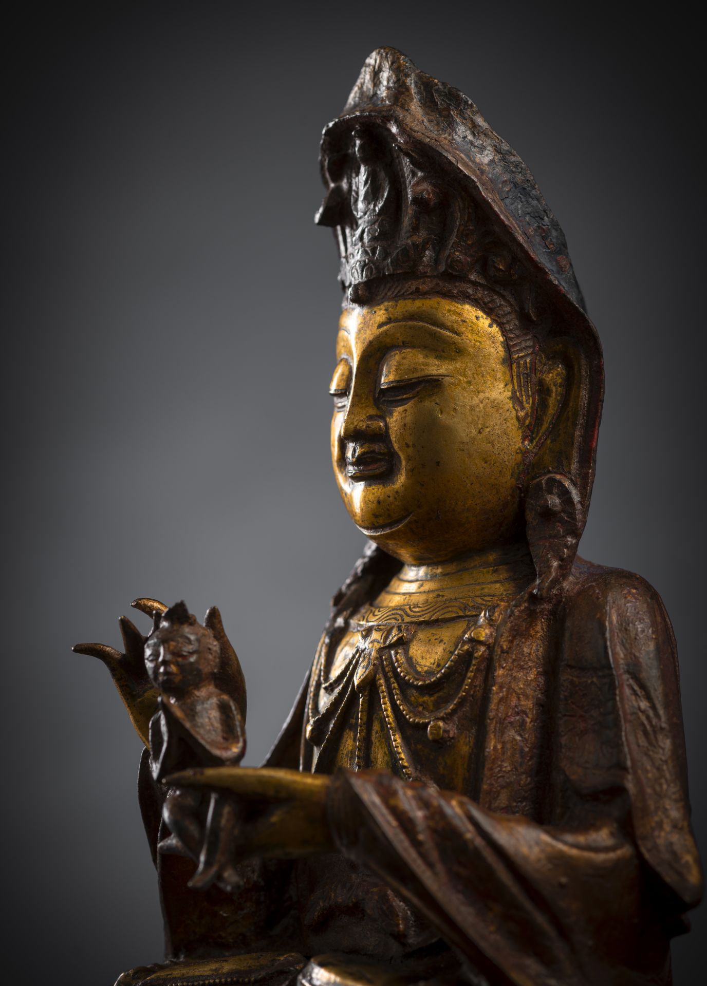 A PART-GILR´T AND GILT-LACQUERED BRONZE FIGURE OF SEATED GUANYIN HOLDING A BOY - Image 3 of 4