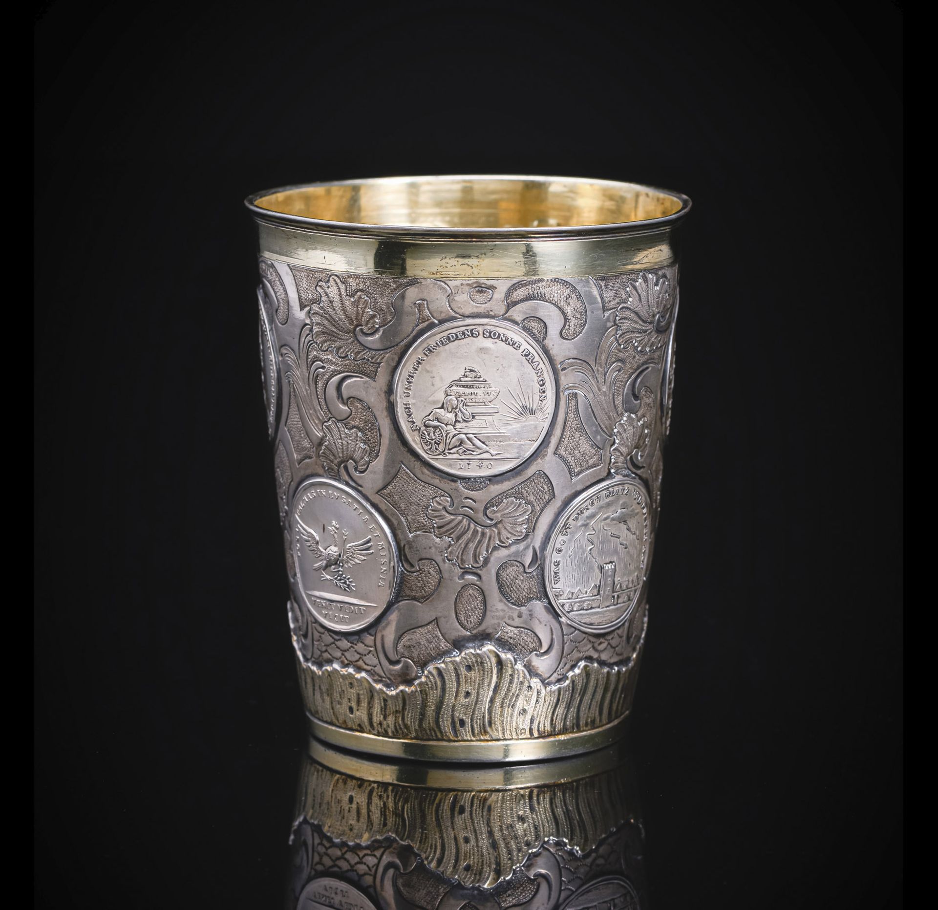 A GERMAN BAROQUE PARTIAL GILT SILVER BEAKER WITH COINS