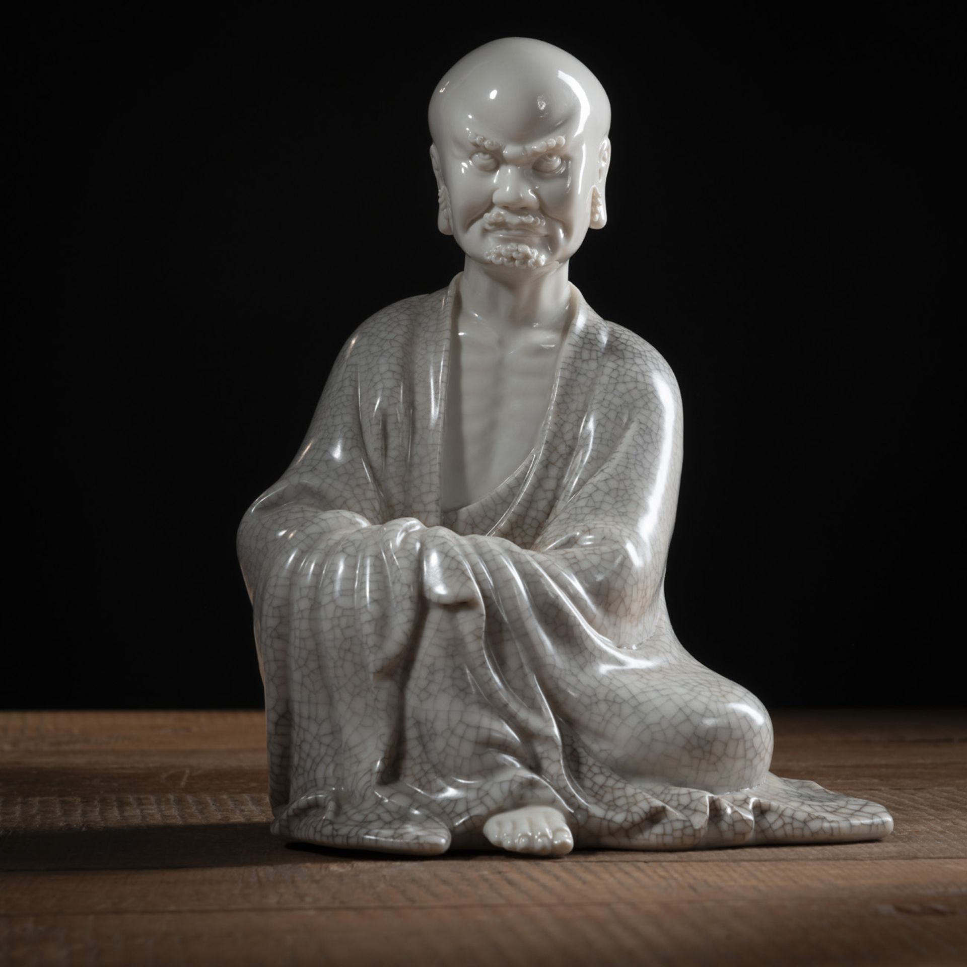 A SEATED DEHUA FIGURE OF A LUOHAN, PARTLY CRACKLED