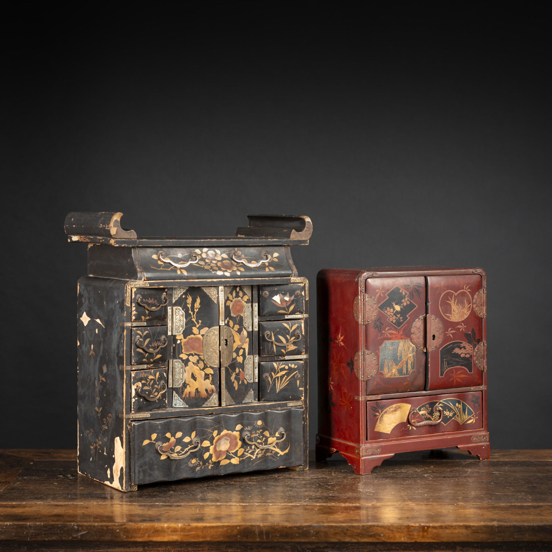 TWO SMALL BLACK AND RED LACQUERED CABINETS WITH DRAWERS AND FLORAL DECORATION, PARTLY PAINTED GOLD