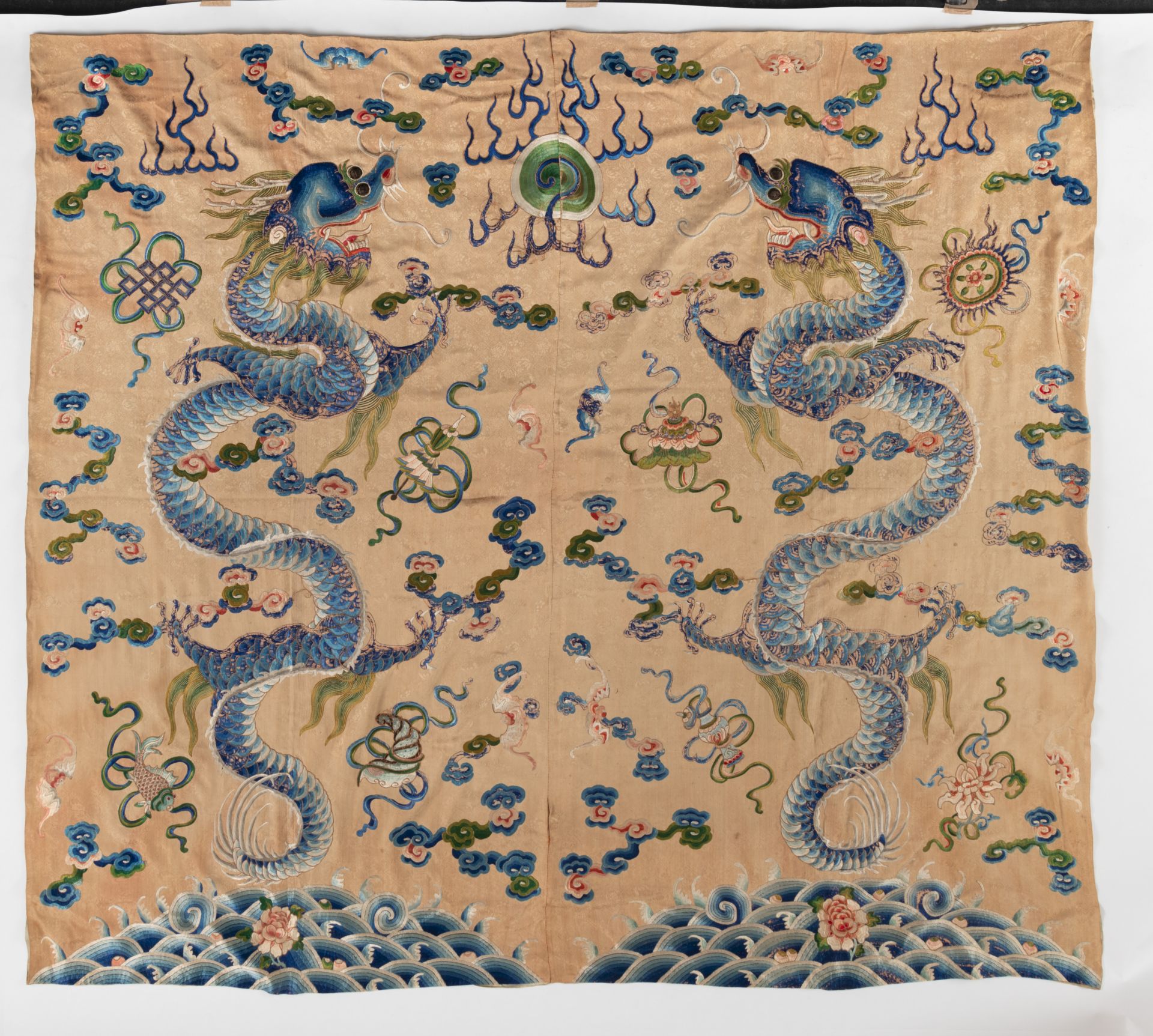 A LARGE BEIGE-GROUND SILK EMBROIDERY DEPICTING TWO IMPRESSIVE DRAGONS CHASING A FLAMING PEARL AND A