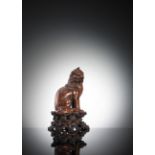 A CARVED WOOD FIGURE OF A 'XIEZHI' SEATED ON A CLOUD BASE