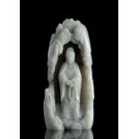 A RARE PALE CELADON JADE FIGURE OF GUANYIN IN A GROTTO