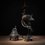 A BRONZE CANDLESTICK IN THE SHAPE OF A CRANE STANDING ON A TURTLE AND A SMALL BRONZE TRIPOD INCENSE