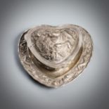 A HEART-SHAPED LIDDED SILVER BOX WITH DRAGONS AND WATER BUFFALO IN RELIEF WITH SAUCER