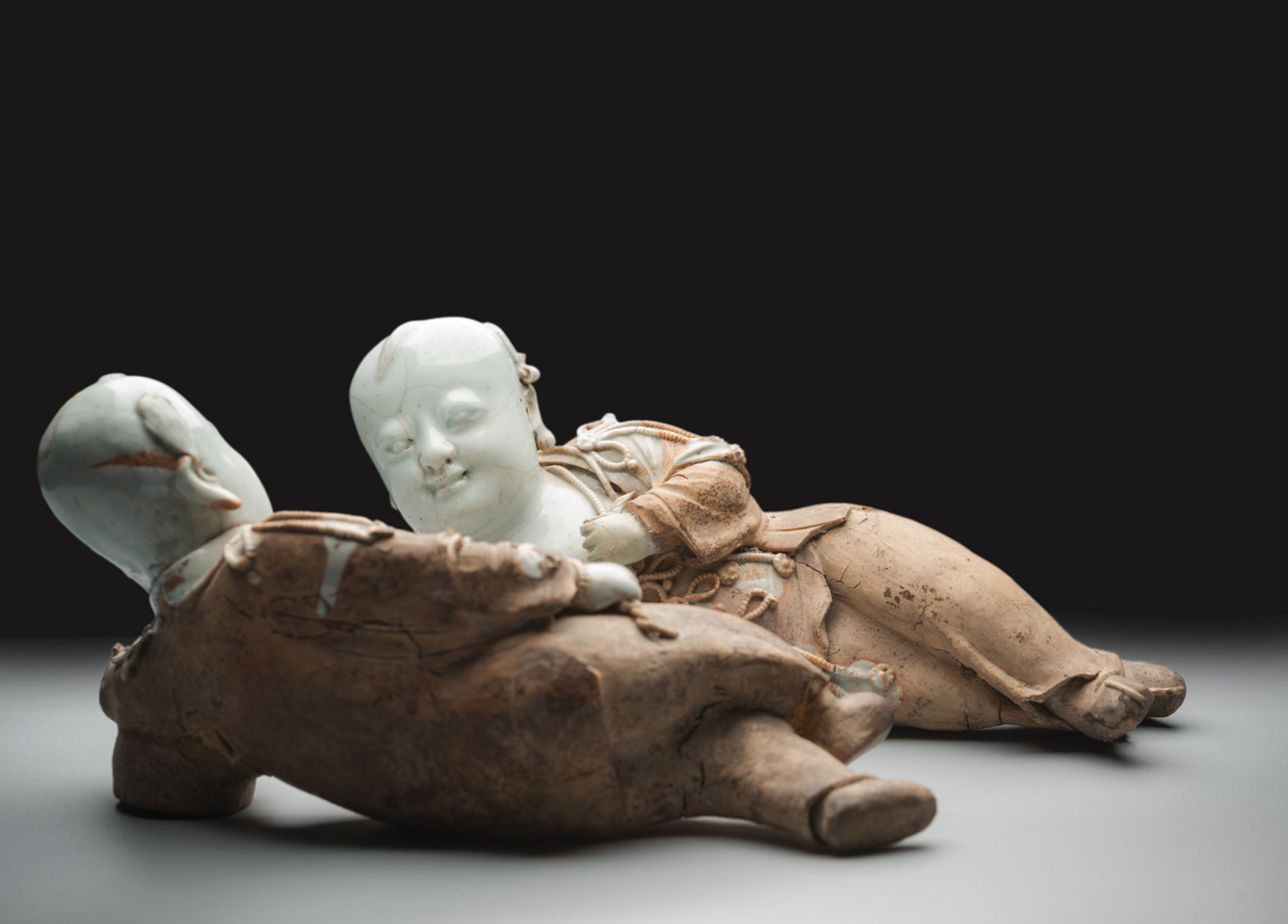 A VERY RARE PAIR OF PART-GLAZED QINGBAI MODELS OF RECLINING BOYS - Image 5 of 6