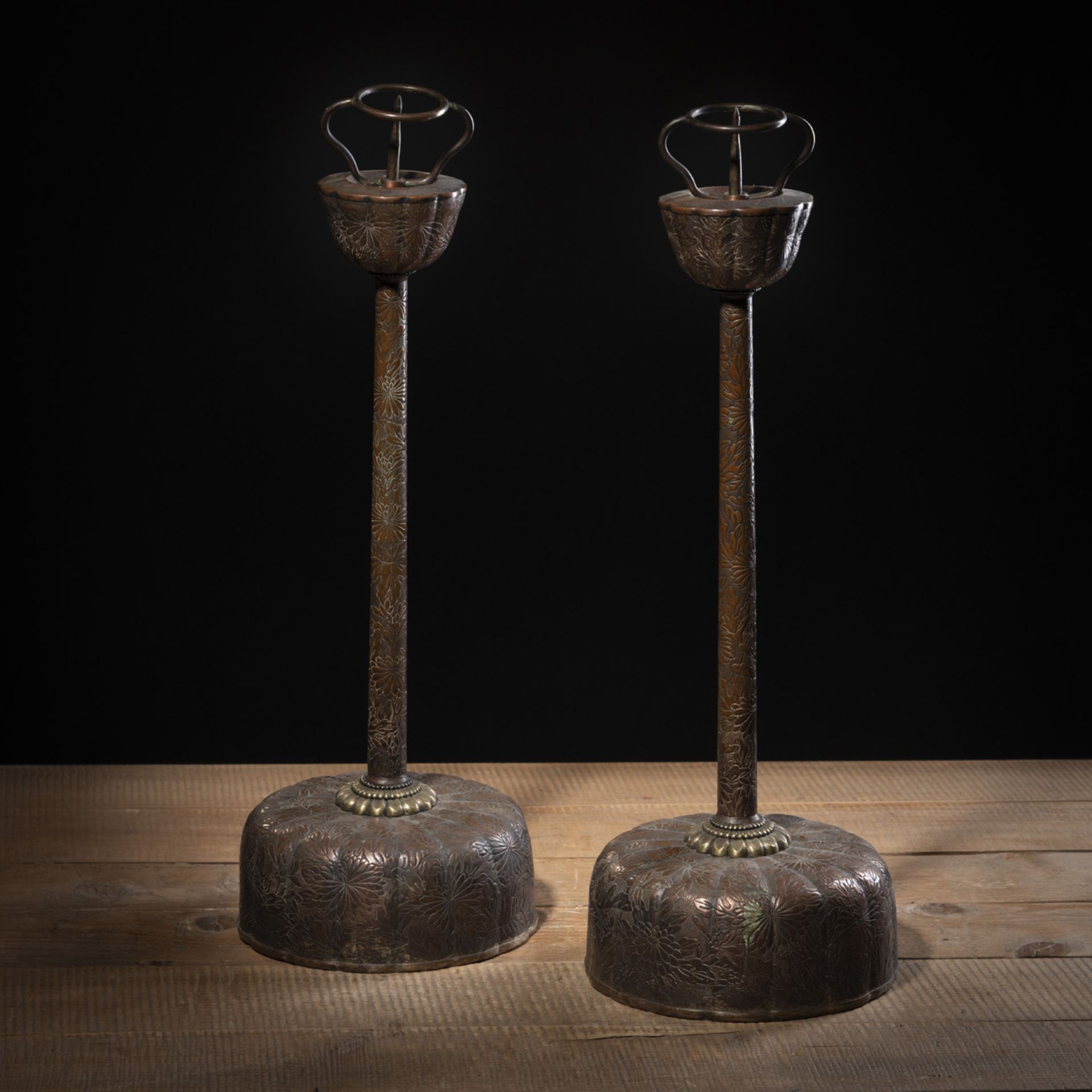 A PAIR OF COPPER FLORAL RELIEF CANDLESTICKS