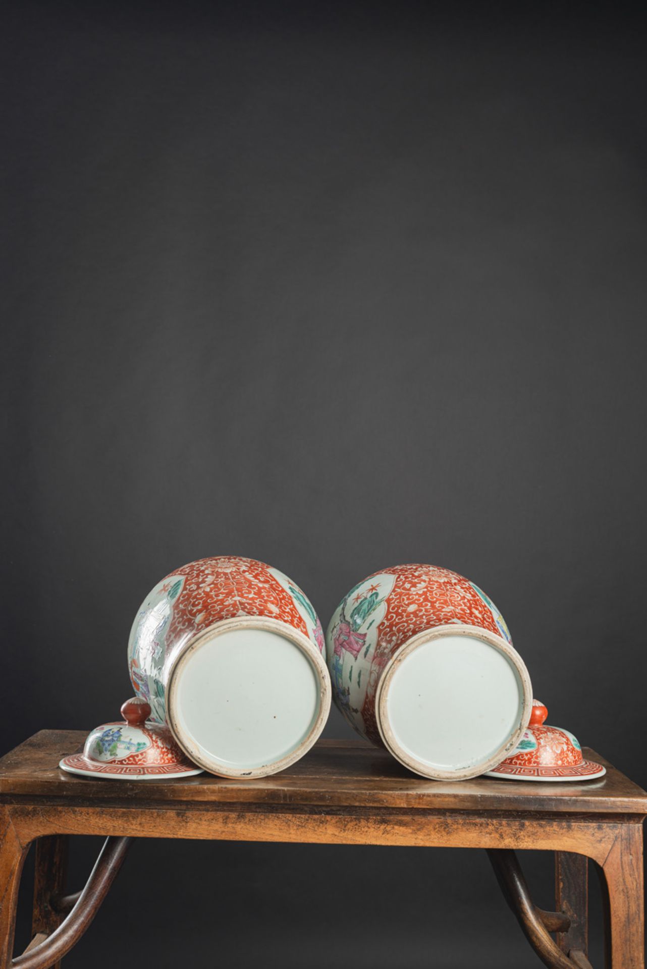 A PAIR OF IRON-RED-GROUND 'FAMILLE ROSE' FIGURAL RESERVES PORCELAIN VASES AND COVERS - Image 4 of 5