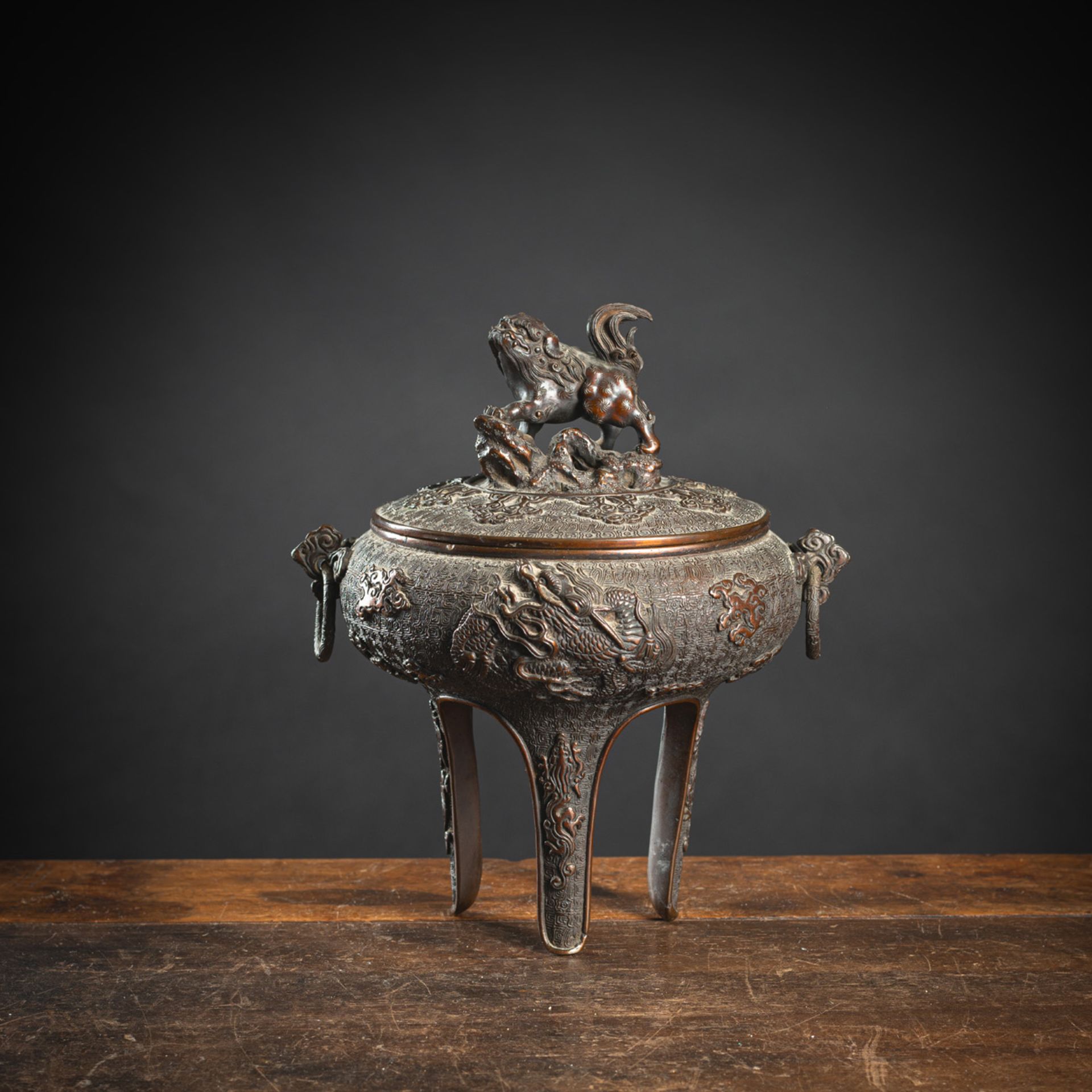 A TRIPOD DRAGON RELIEF BRONZE CENSER AND SHISHI-HANDLED COVER