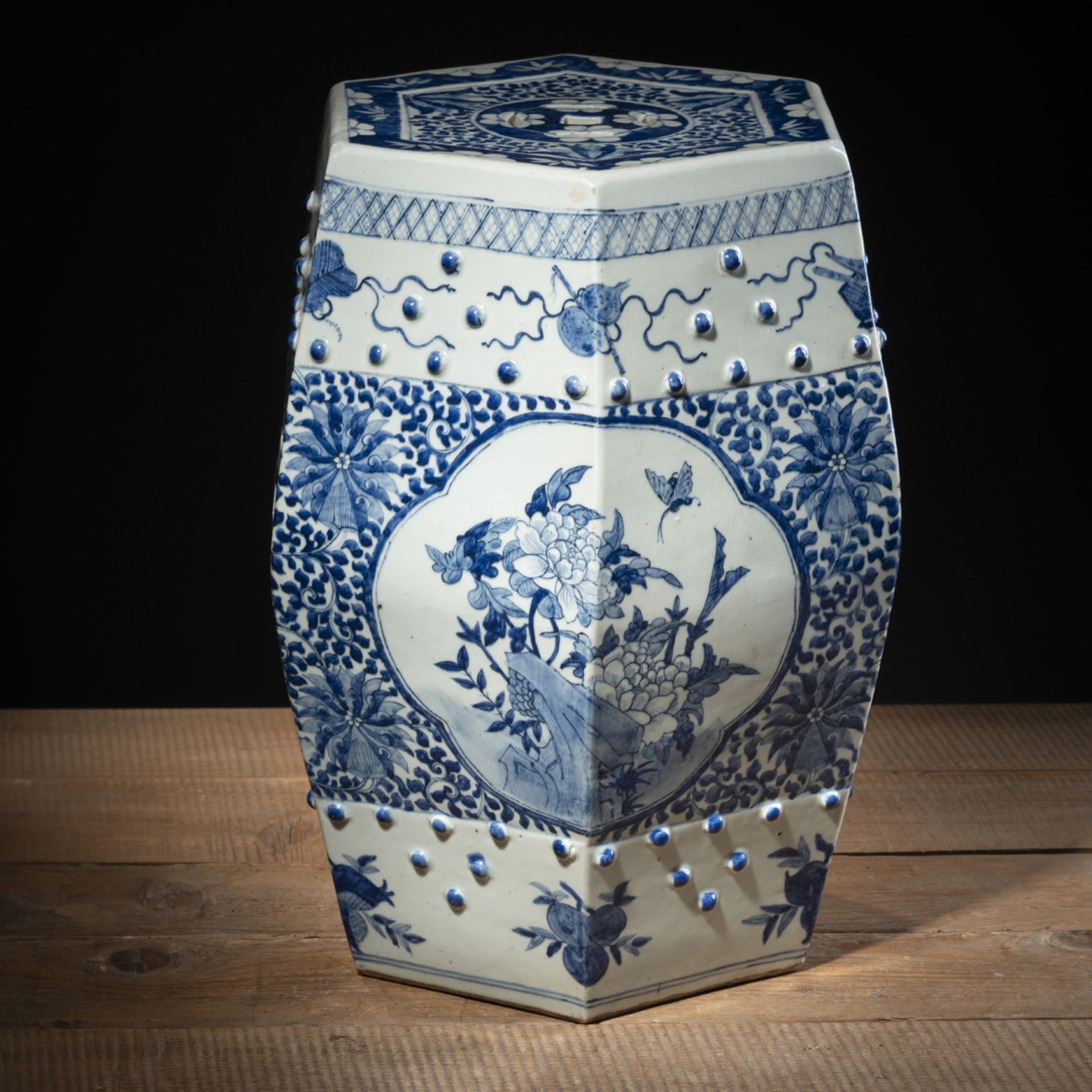 A HEXAGONAL BLUE AND WHITE PORCELAIN GARDEN STOOL WITH CASH COINS, FLOWERS AND LUCKY SYMBOLS DECORA