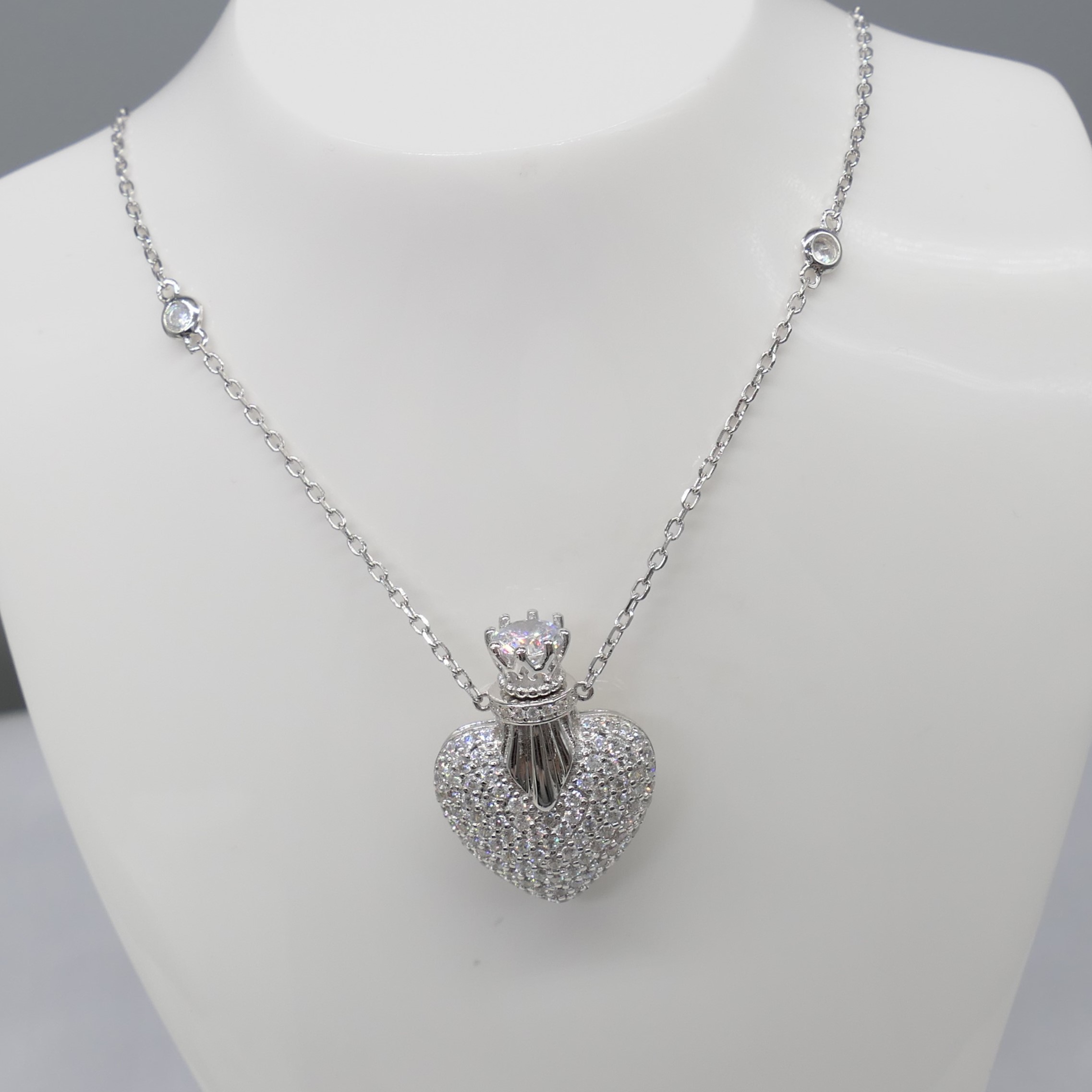 Heart and crown trinket necklace set with multiple stones.