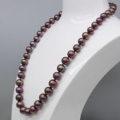Purple/brown freshwater pearl-strung necklace with yellow and white gold swirl design clasp.