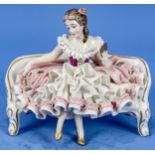 "Junges Fräulein" auf Sofabank sitzend mit Handspiegel, in Rokoko- Manier gestaltete Figur, polychr