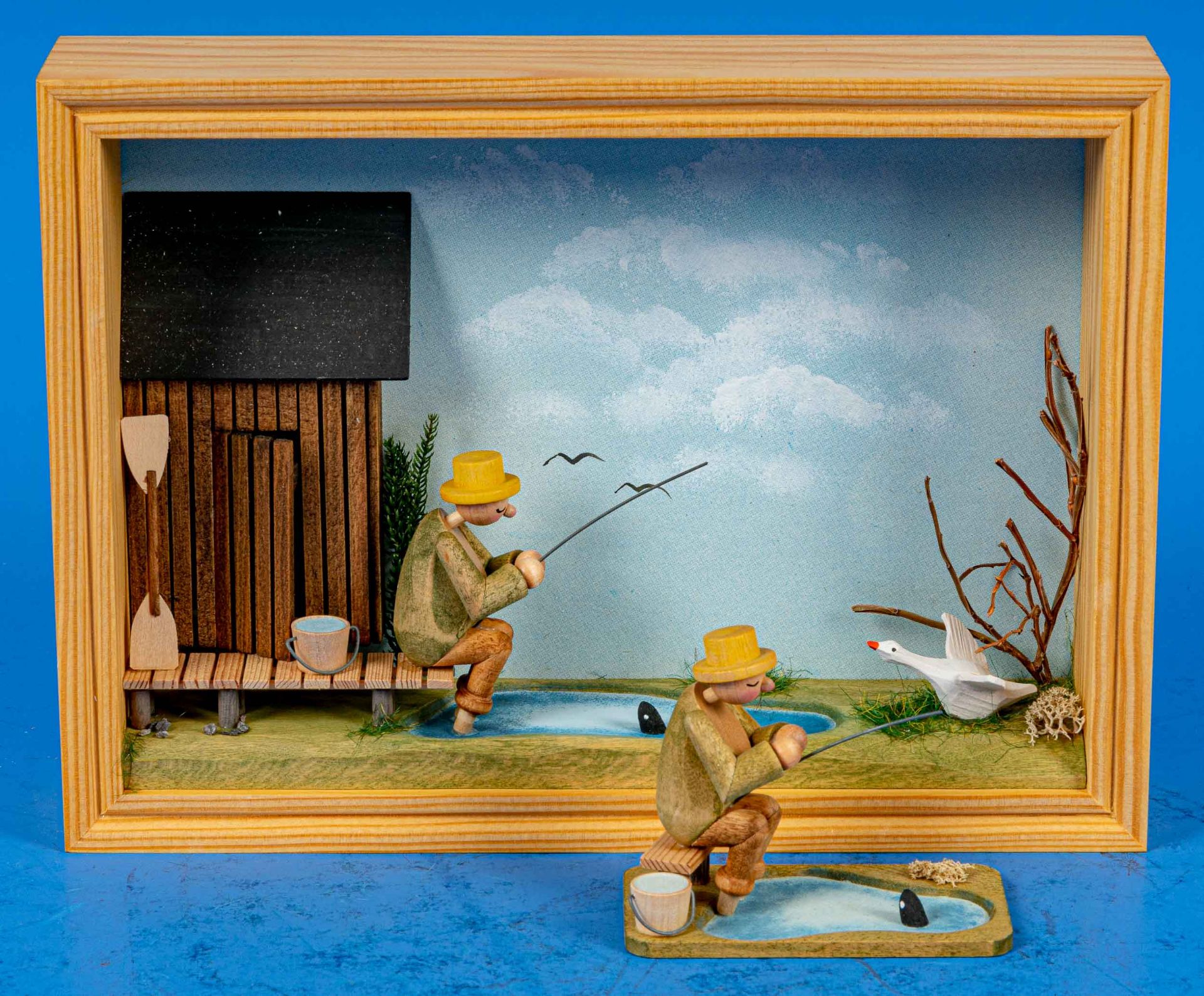 "Angler"-Diorama in Holzkasten (ca. 21 x 16 cm), Handarbeit; sowie die selbe Figur ohne Staffage au