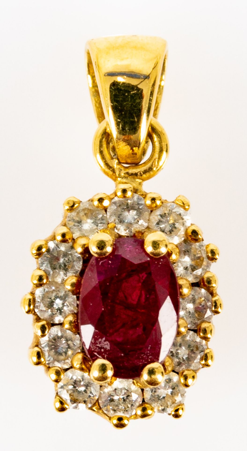 Feiner, zarter 18 K Gelbgold-Kettenanhänger, mittig mit Rubin-Cabochon, von 12 Diamanten im Brillan