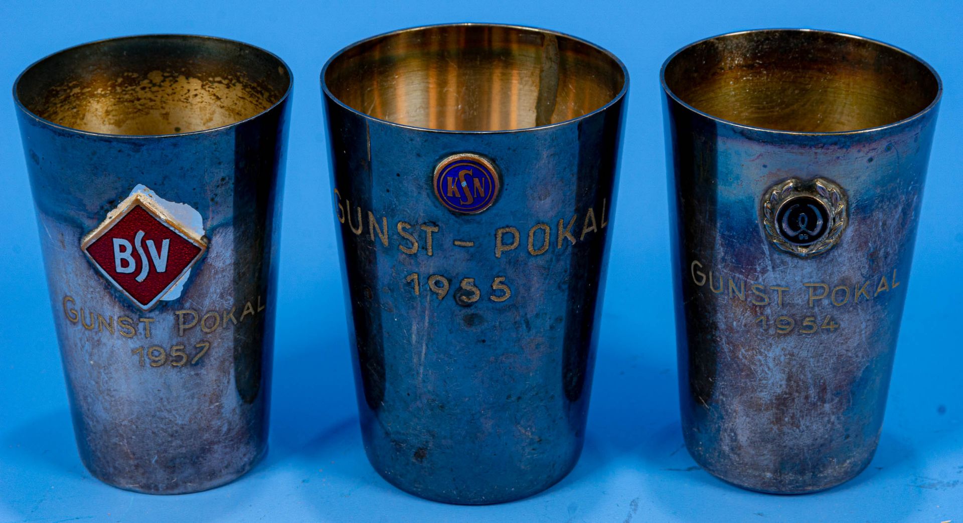 3 x "GUNST" - Pokal aus den Jahren 1954, 1955 & 1957. Versilberte Becher mit aufgelegten, verschied