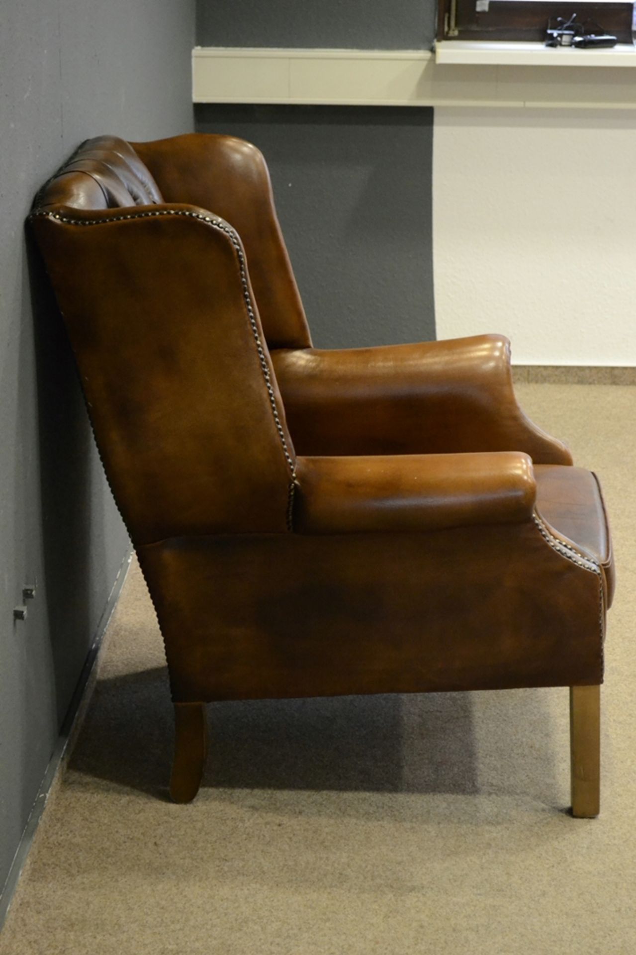 Stilvoller Ohrenbacken-Sessel, bräunliches Leder, leicht eingerollte Armlehnen, der Rücken mit soge - Bild 7 aus 10