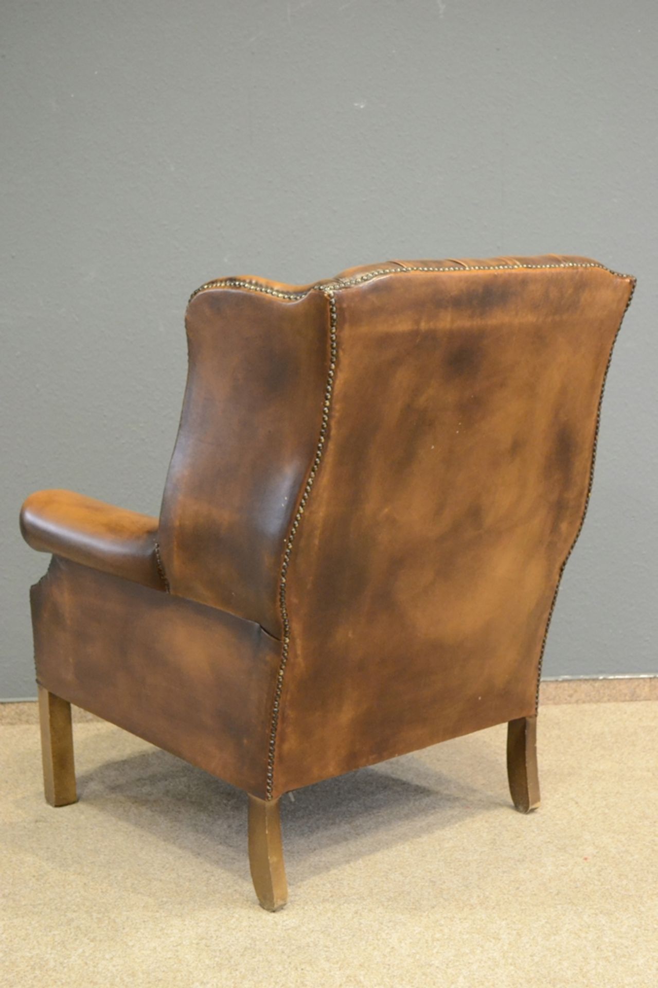 Stilvoller Ohrenbacken-Sessel, bräunliches Leder, leicht eingerollte Armlehnen, der Rücken mit soge - Bild 6 aus 10