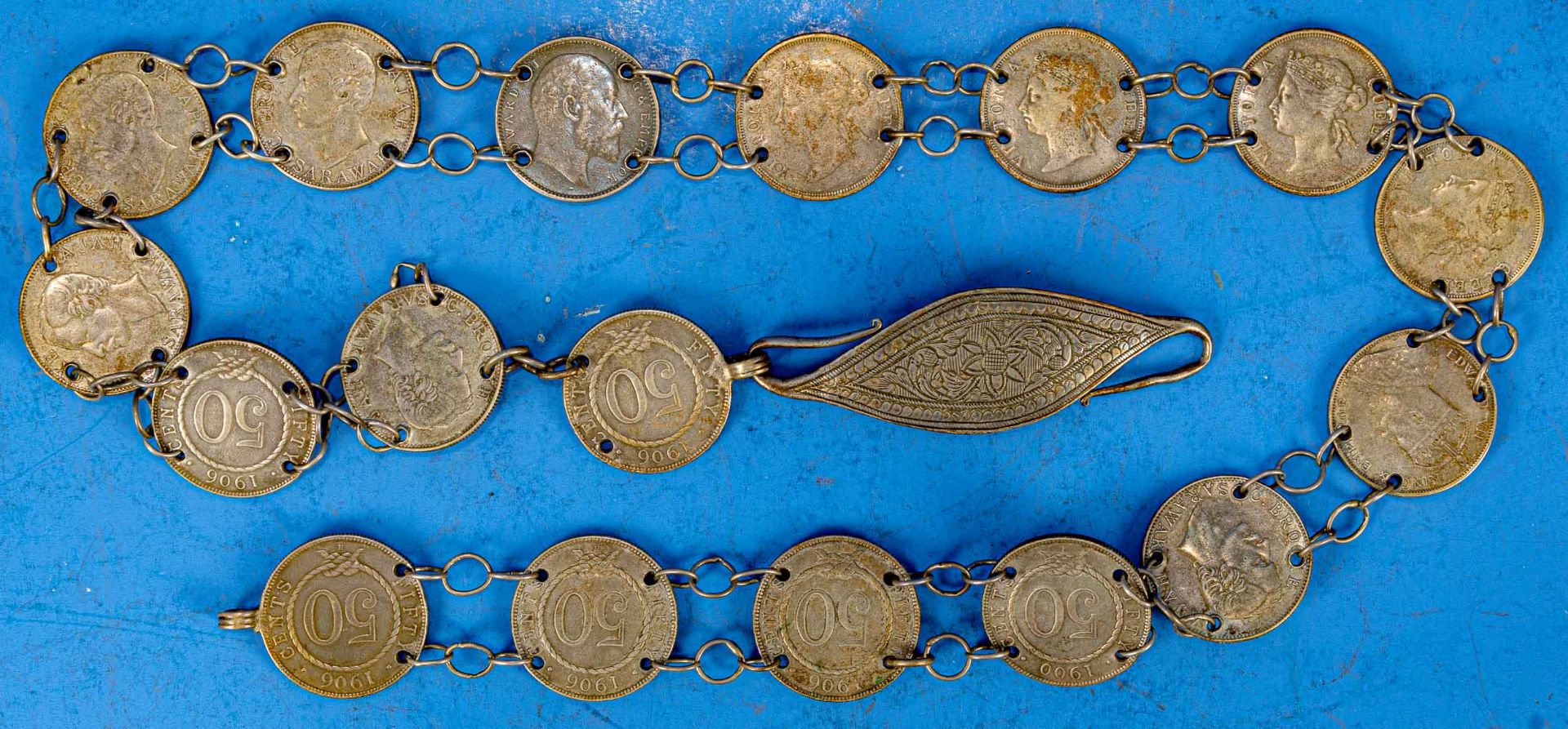 18gliedriger "Münzgürtel", die Münzen aus der Zeit um 1900 u.a. aus Indien & Malaysia stammend. 1 Ö