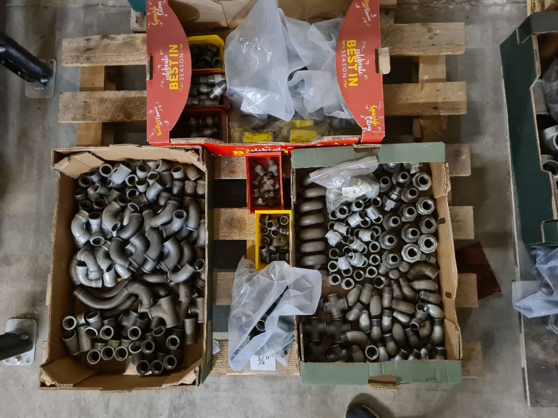 Pallet of 0.5" and 0.75" malleable pipe fittings.